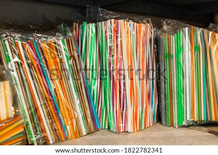 Set of multicolored plastic straws on a shelf in a store