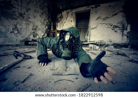 Post apocalyptic survivor in gas mask asking for help in a ruined building. Environmental disaster, armageddon concept. Royalty-Free Stock Photo #1822912598
