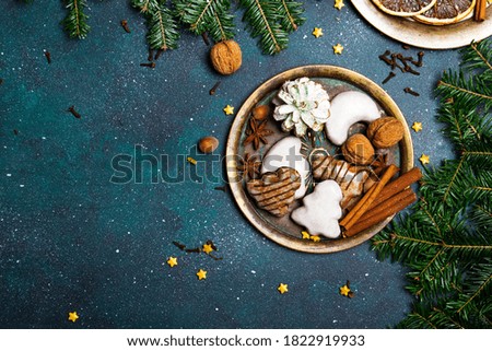 Christmas background with decorations.Gingerbread cookies, nuts and fir twigs on dark background. Copy space