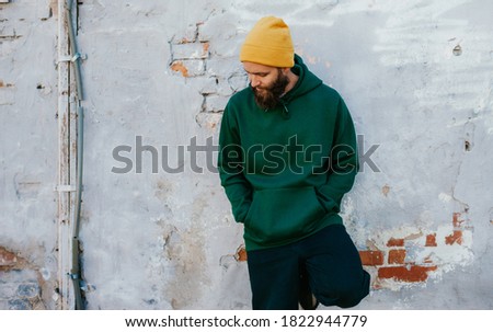 City portrait of handsome hipster guy with beard wearing green (watercolor) blank hoodie with space for your logo or design. Mockup for print Royalty-Free Stock Photo #1822944779