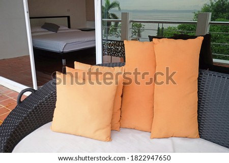 Orange pillows on sofa at balcony of bedroom