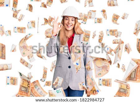 Beautiful young woman wearing architect hardhat smiling positive doing ok sign with hand and fingers. successful expression.