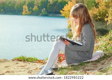 Happy child reading book on nature education in park travel