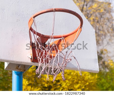 an old basketball homemade ring hanging on a power post. Emotion of childhood memories. Copy space on a blue summer sky background
