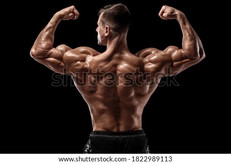 Muscular man showing back muscles, isolated on black background. Strong male rear view Royalty-Free Stock Photo #1822989113