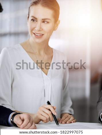 Elderly businessman and group of business people discussing contract in sunny office, close-up