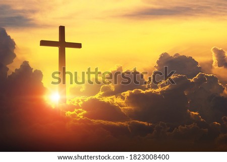 The Cross of Christ in the yellow, stunningly dramatic sky. The cross on a huge cloud with the rising sun behind. epic clouds