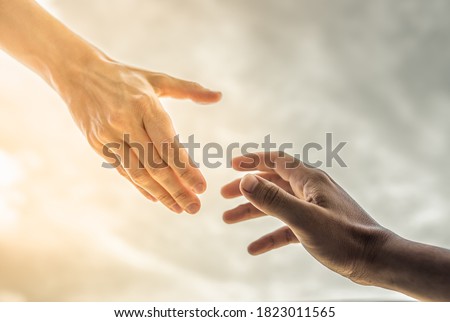 Hand reaching out to help someone out of the darkness into the light. Religion and salvation concept.  Royalty-Free Stock Photo #1823011565