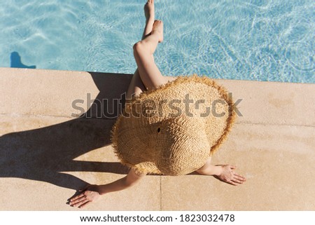 Woman near the pool in a hat top view vacation luxury
