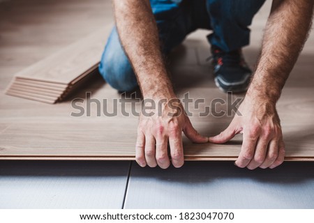 Easy and quick installation of the flooring - connecting laminate locks - DIY floating floor Royalty-Free Stock Photo #1823047070