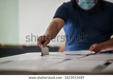 Unrecognizable person casting a vote into the ballot box during corona virus pandemic Royalty-Free Stock Photo #1823052689