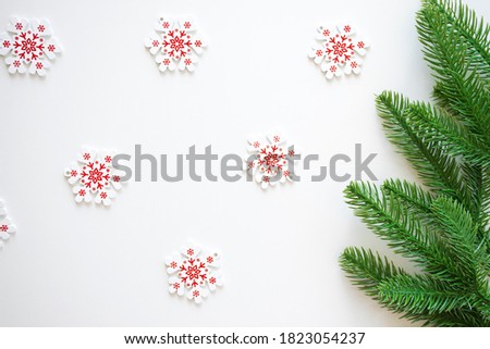 White with red snowflakes and green fir branches on white as Christmas and New Year background