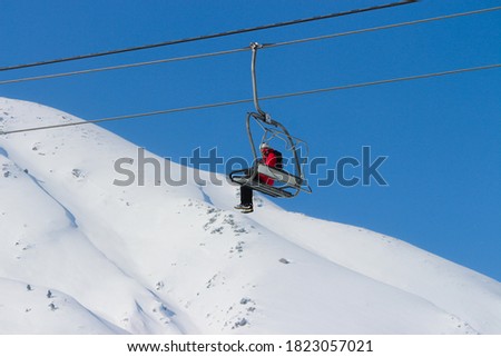 a skier on open cable car going for skking.adventrous snow game is skking.