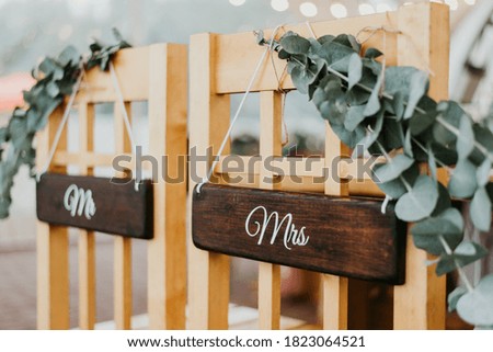Chairs for bride and groom decorated with mr and mrs signs for wedding ceremony