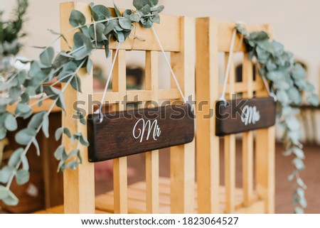 Chairs for bride and groom decorated with mr and mrs signs for wedding ceremony