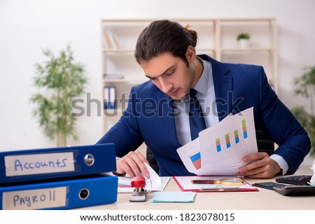 Young male financial manager in the office Royalty-Free Stock Photo #1823078015
