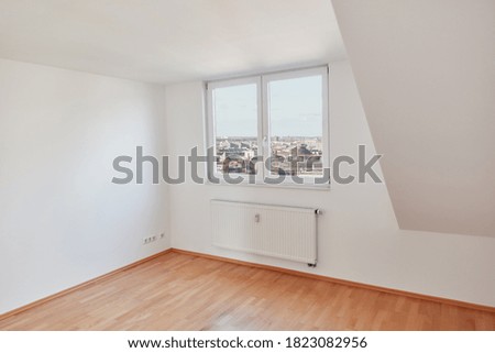 Empty bright room in attic apartment with wooden parquet in Berlin