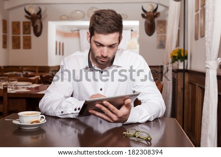 Man Using Digital Tablet At Cafe