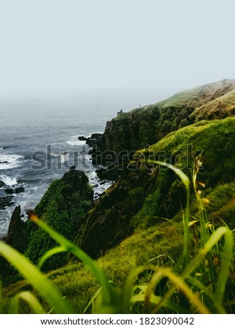 Monsoon Season view of the rough Arabian Sea and Rocky Shoreline near Lower Aguada or also called Devil's Finger, Sinquerim, Goa, India Royalty-Free Stock Photo #1823090042