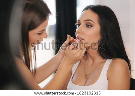 Makeup artist work in her beauty studio. Portrait of Woman applying makeup. Professional make up master. Beautiful make up artist start making a makeup for brunette woman