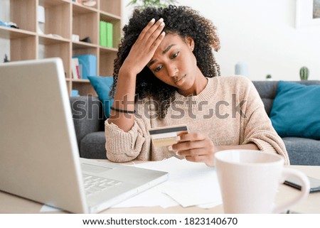 Afro woman with problem using credit card for online shopping Royalty-Free Stock Photo #1823140670