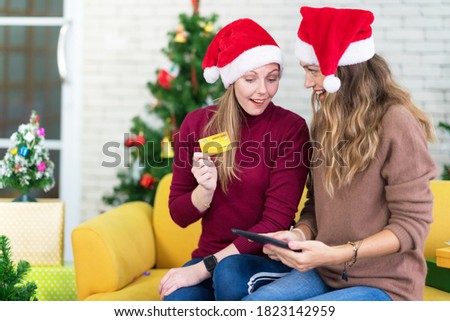 portrait of woman and friend showing a blank credit card in christmas holidays, Christmas and New Year shopping on the Internet, payment by credit card.