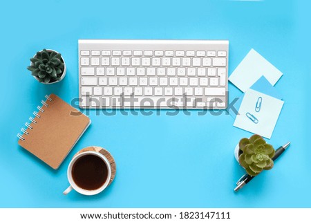 blue office desk background with smartphone with blank screen mockup, laptop computer, cup of coffee and supplies. Top view with copy space, flat lay.