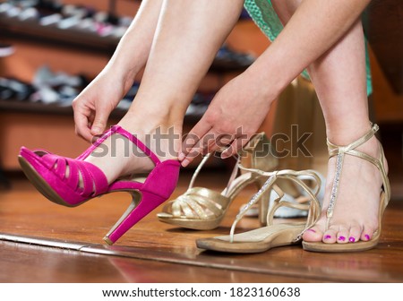 Female is sitting and gonna to trying on shoes in shoes shop.