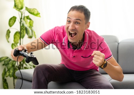 a man plays with a joystick at home on a black background