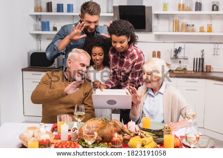 Selective focus of multiethnic family having video call on laptop during thanksgiving