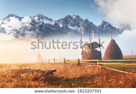Amazing mountain landscape with fog and a haystack in autumn. Location place Carpathian national park, Ukraine, Europe. Artistic picture. Beauty world.