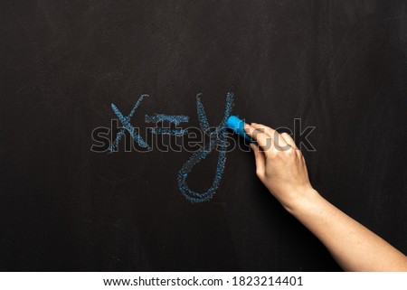 formula equation x = y is written in chalk on a black slate board.