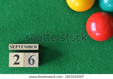 September 26, number cube with balls on snooker table, sport background.