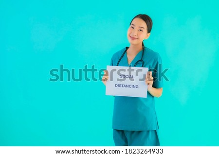 Portrait beautiful young asian doctor woman show sign with Social distancing on blue isolated background
