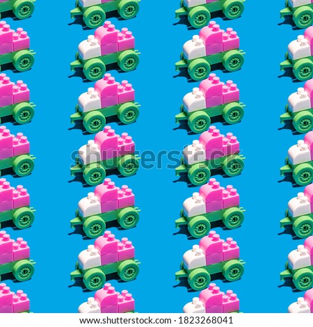 Seamless pattern with train car made from plastic building toy blocks on blue background.
