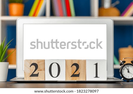 Wooden cubes 2021 Year on working table with open laptop