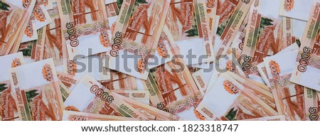 Russian money banner. Rubles of five thousands denominations lie on the table mixed. Closeup. Selective focus.