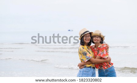 Two asian girl wear colorful shirt in happy emotion at beach.
