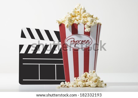 a bag full of popcorn and a black clapper board with white background
