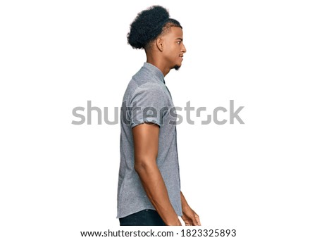African american man with afro hair wearing casual clothes looking to side, relax profile pose with natural face with confident smile. 