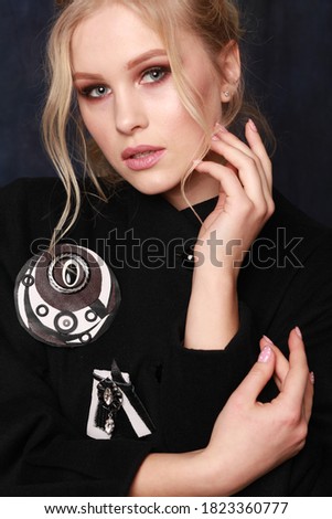 high fashion portrait of elegant woman in modest black dress, decorated with brooch. Studio shoot. Concept of a perfect lifestyle clothes and accessories for every day
