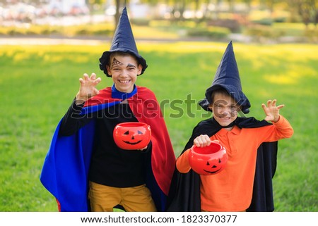 Happy children in the park in Halloween costumes celebrate the holiday