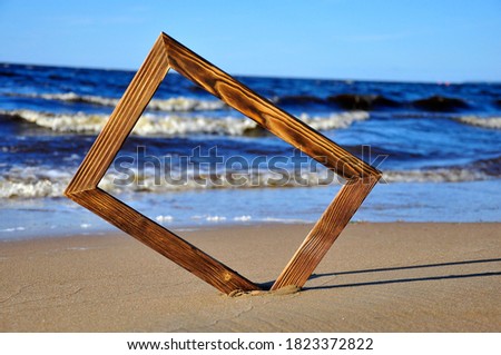 Photo frame on the beach by the sea. Sea surf background.