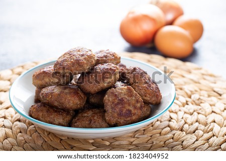 Minced meatball in bowl with eggs on the table. Homemade traditional Turkish meatballs. Royalty-Free Stock Photo #1823404952