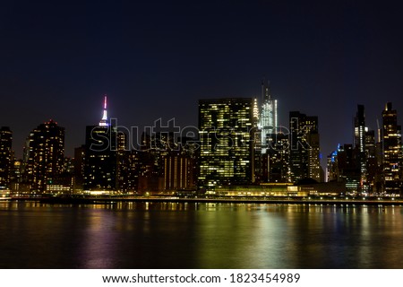 New York City panorama with Manhattan skyline at night over East River
