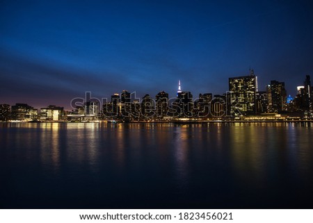 New York City panorama with Manhattan skyline over East River at night