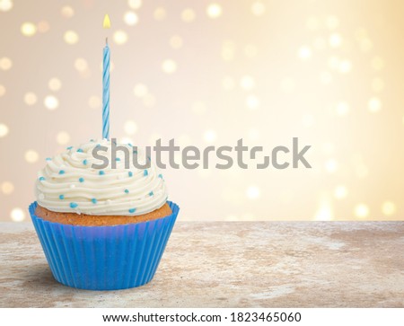 Happy Birthday delicious cupcake with candle on bokeh background