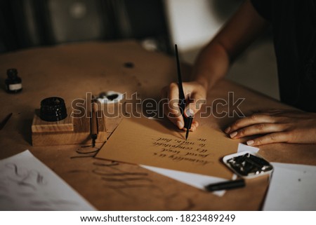 Person writing letter with fountain pan.