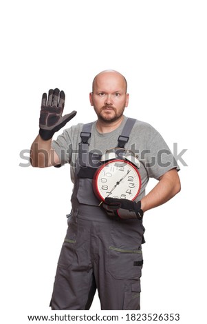 An aged 40 car mechanic holding a clock and showing a stop sign isolated on a white background