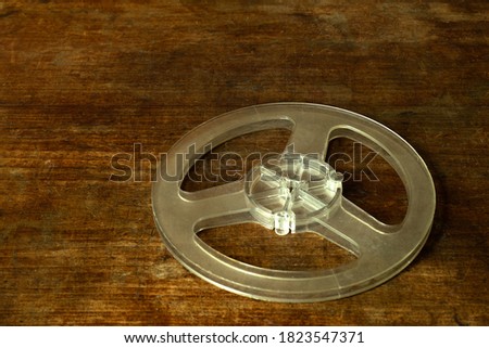 Plastic reel from a reel-to-reel tape recorder on a wooden table